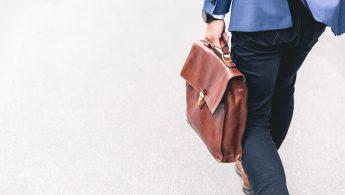 person walking holding brown leather bag